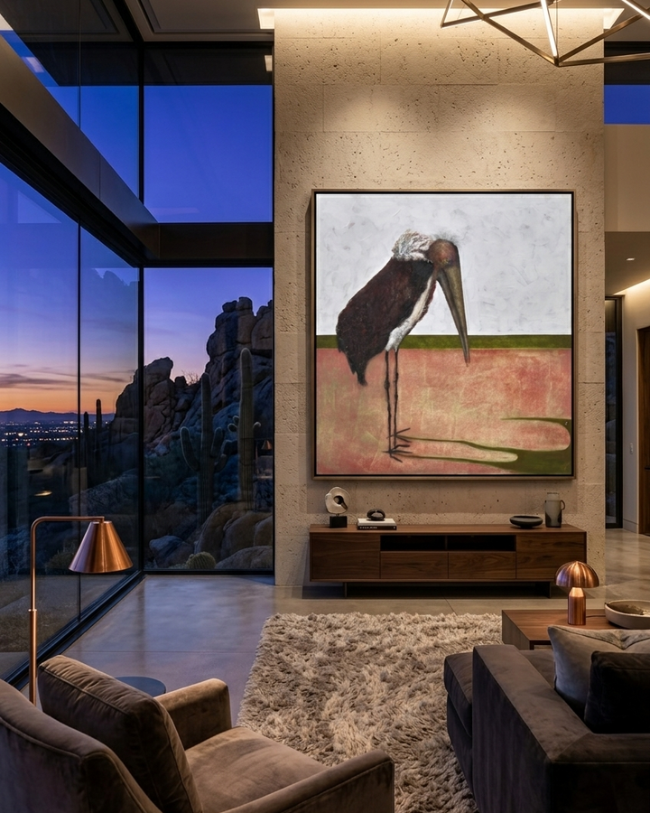 Modern living room with a large painting on the wall, glass walls showing a desert view, and comfortable furniture.