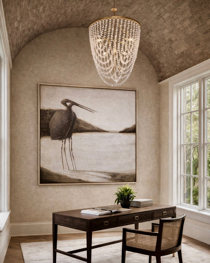 Elegant home office with a chandelier, desk, and large wall art.