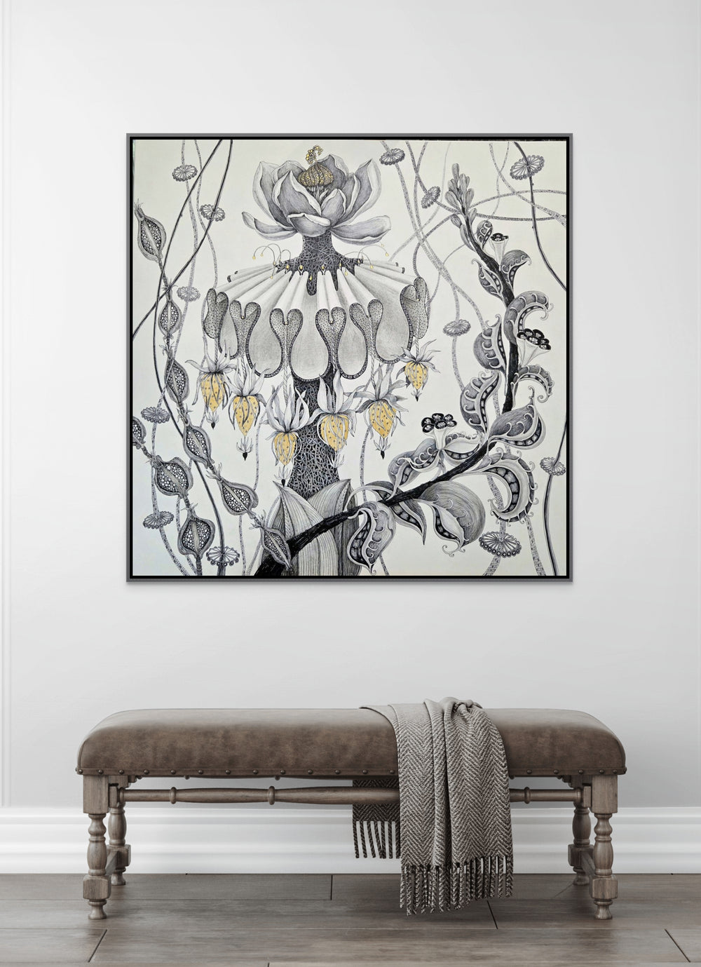 Decorative floral artwork on a wall above a bench with a blanket.