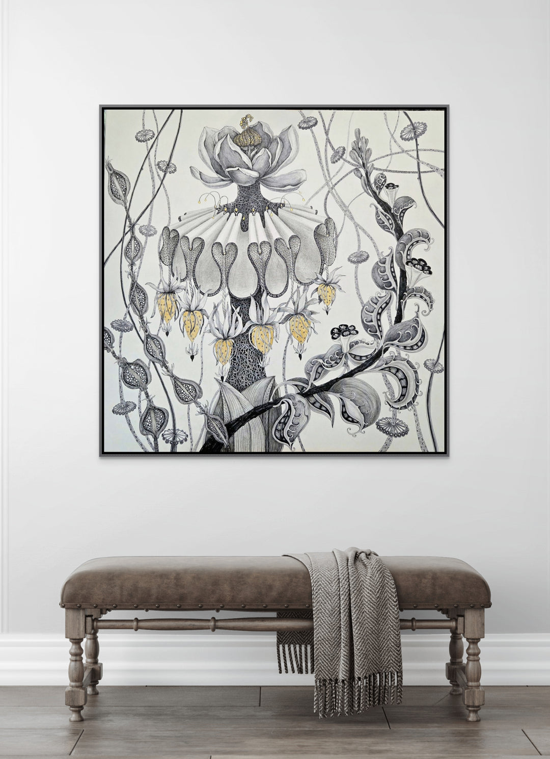 Decorative floral artwork on a wall above a bench with a blanket.