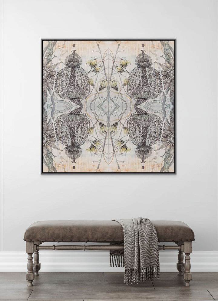 Framed abstract art piece on a wall above a bench with a blanket.