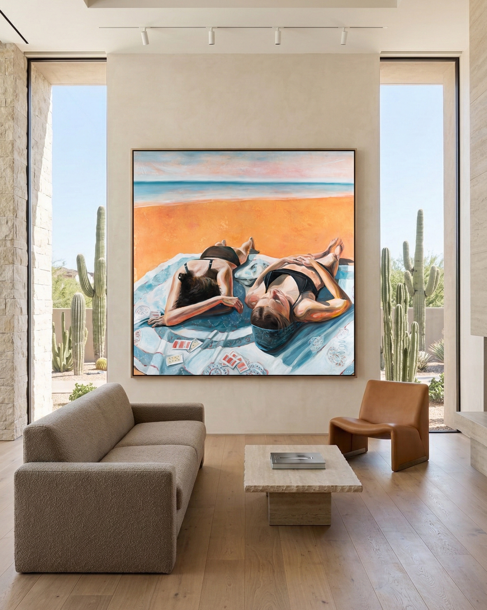 Modern living room with a large painting of two people on a beach, cacti outside, and a sofa.