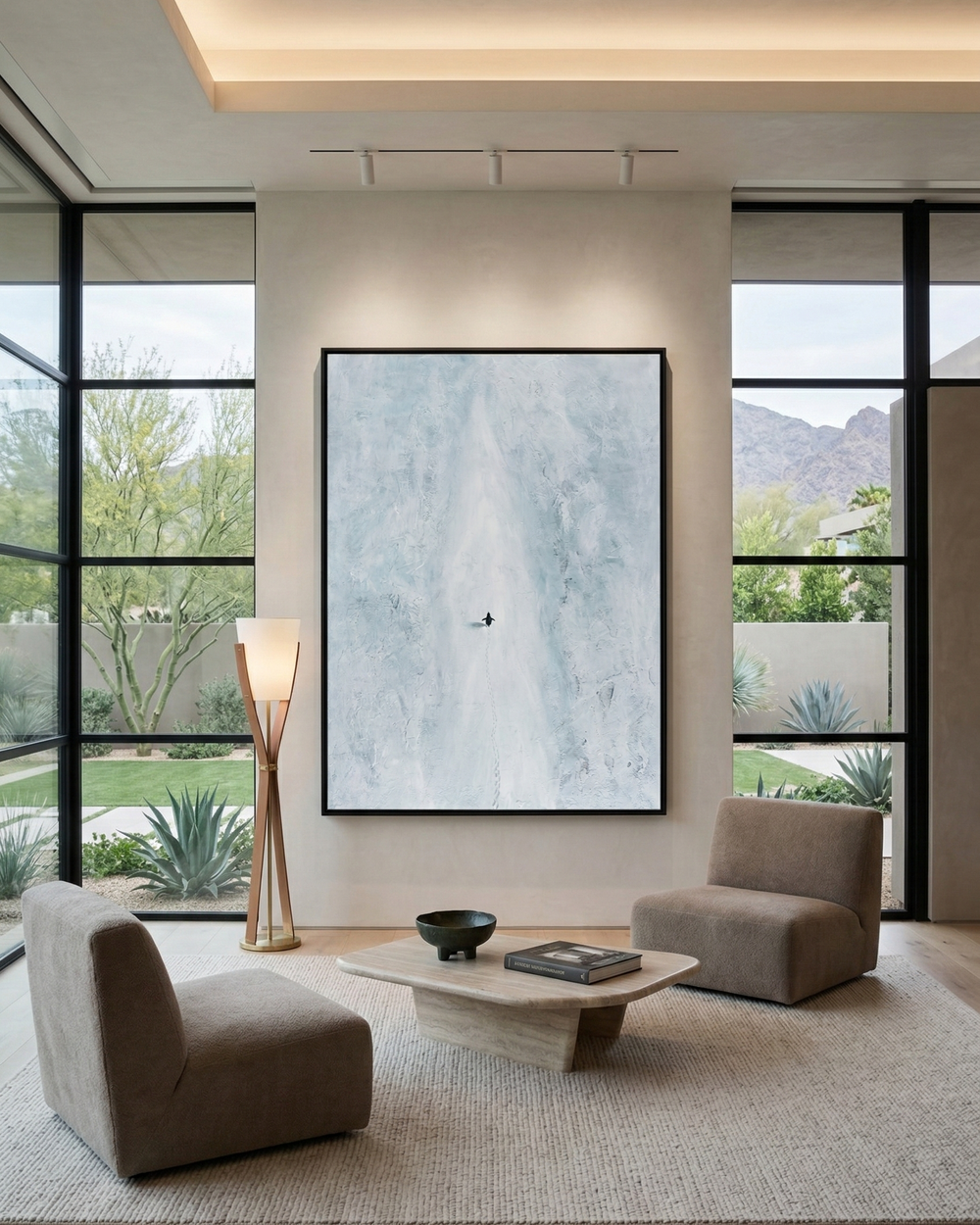 Modern living room with large windows, neutral decor, and a framed abstract painting.