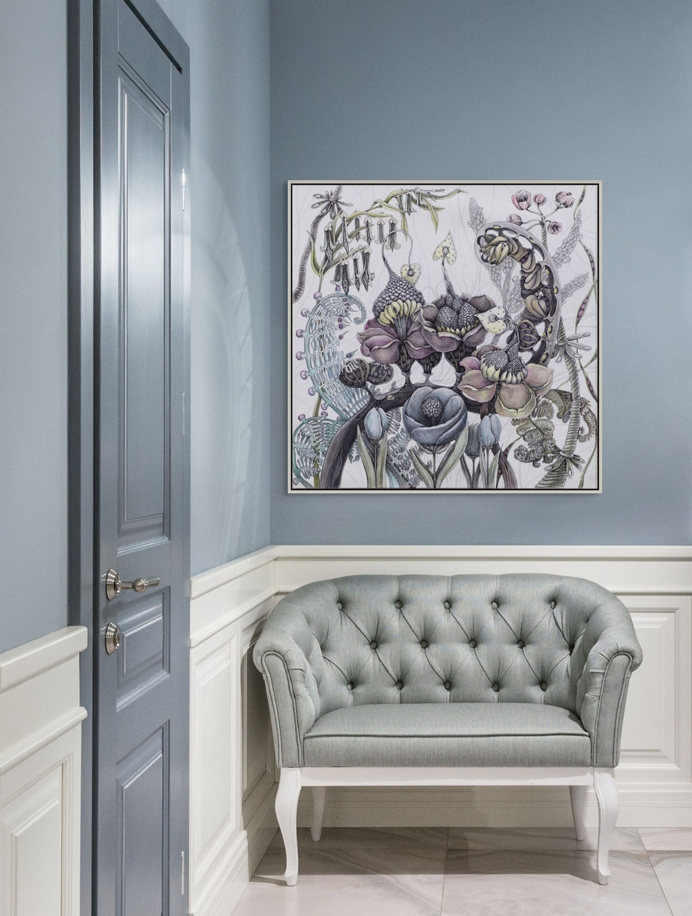 Gray tufted sofa in a room with a decorative floral painting on the wall.