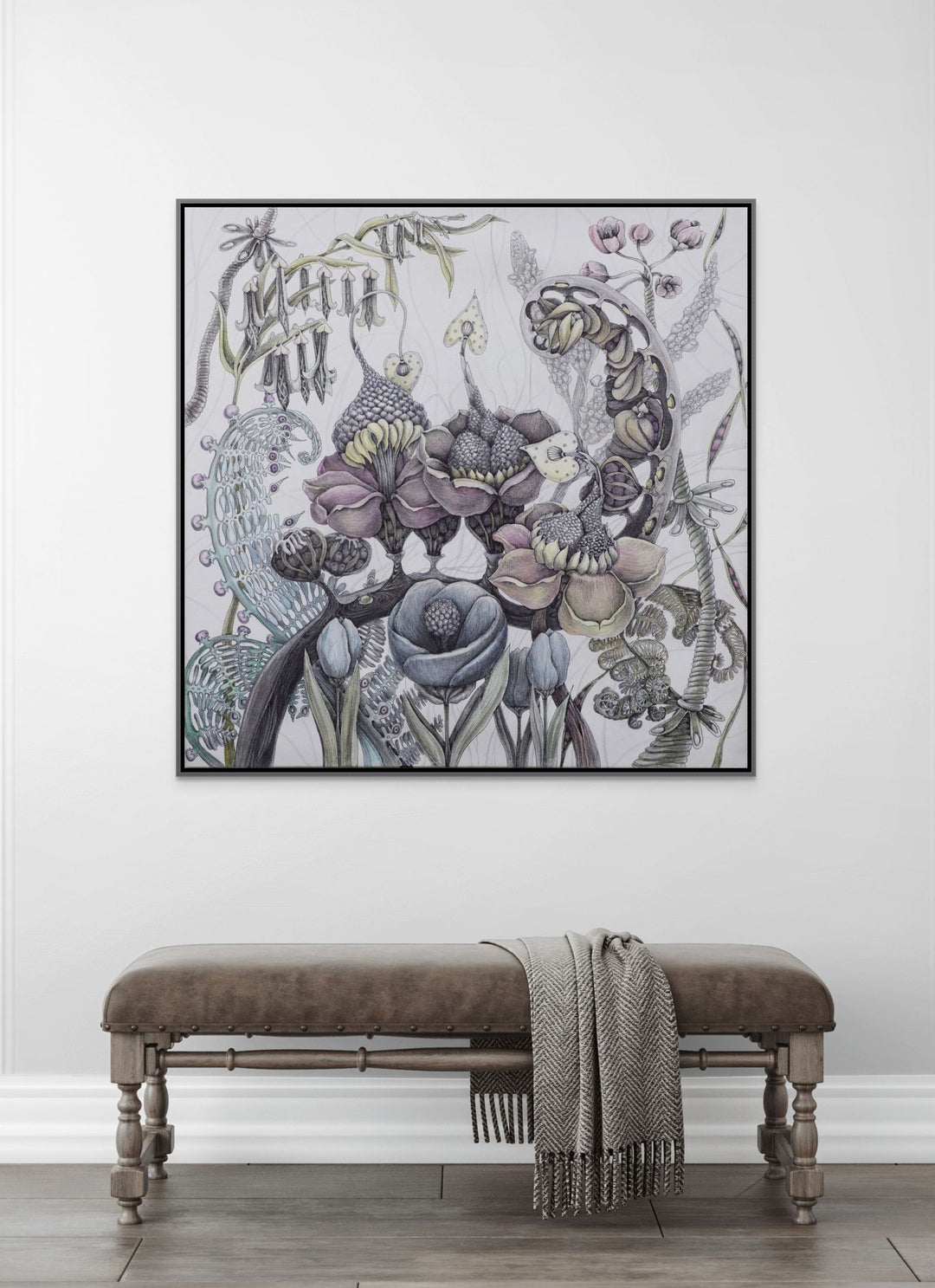Decorative floral artwork on a white wall above a wooden bench with a blanket.