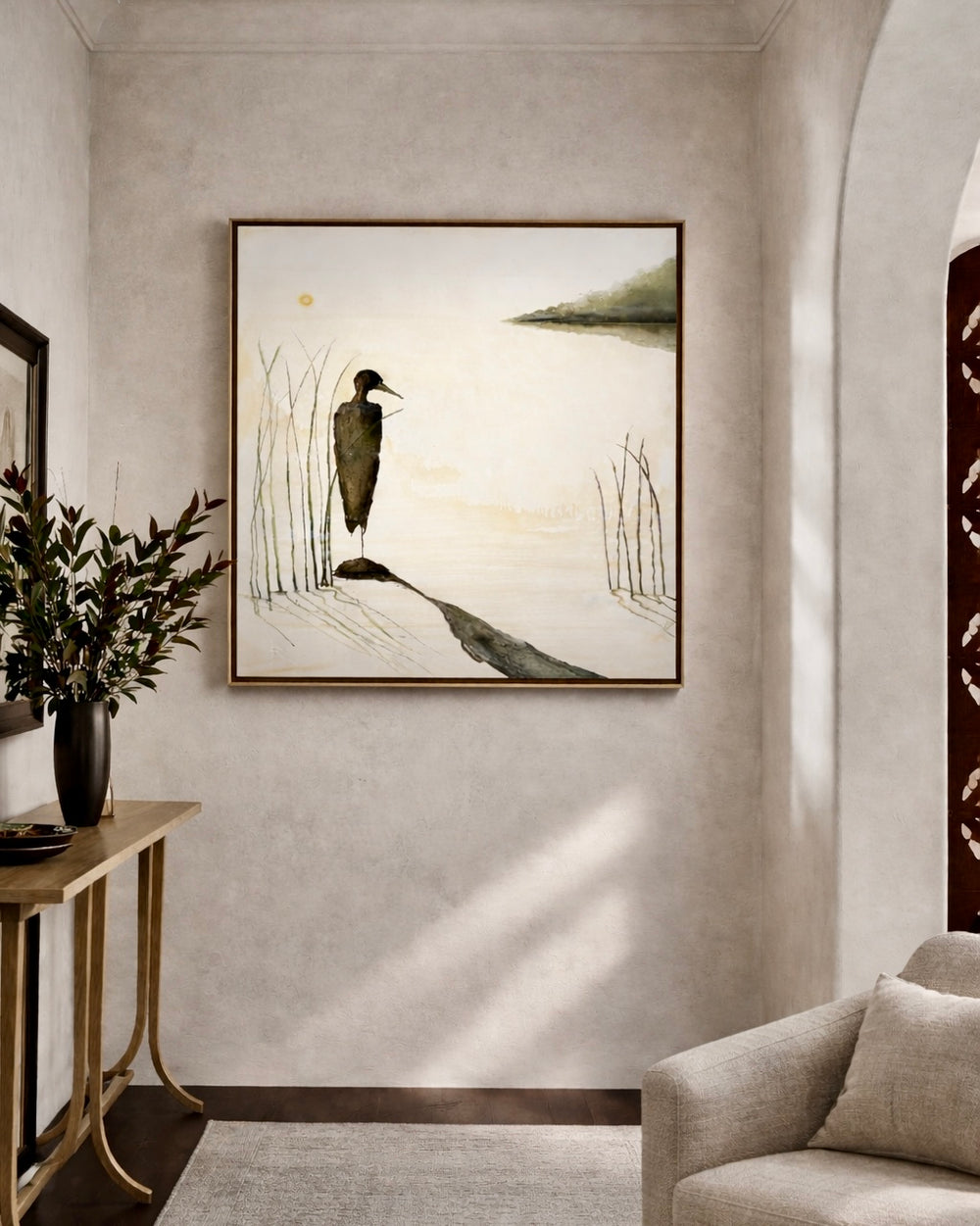 Framed artwork of a bird and landscape on a wall in a living room.