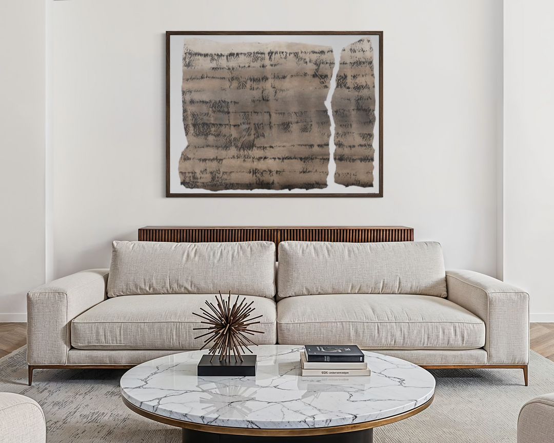 Modern living room with a beige sofa, marble coffee table, and abstract art on the wall.