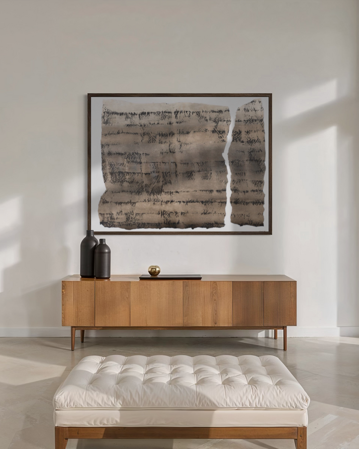 Modern interior with wooden console table, white ottoman, and abstract art on wall.