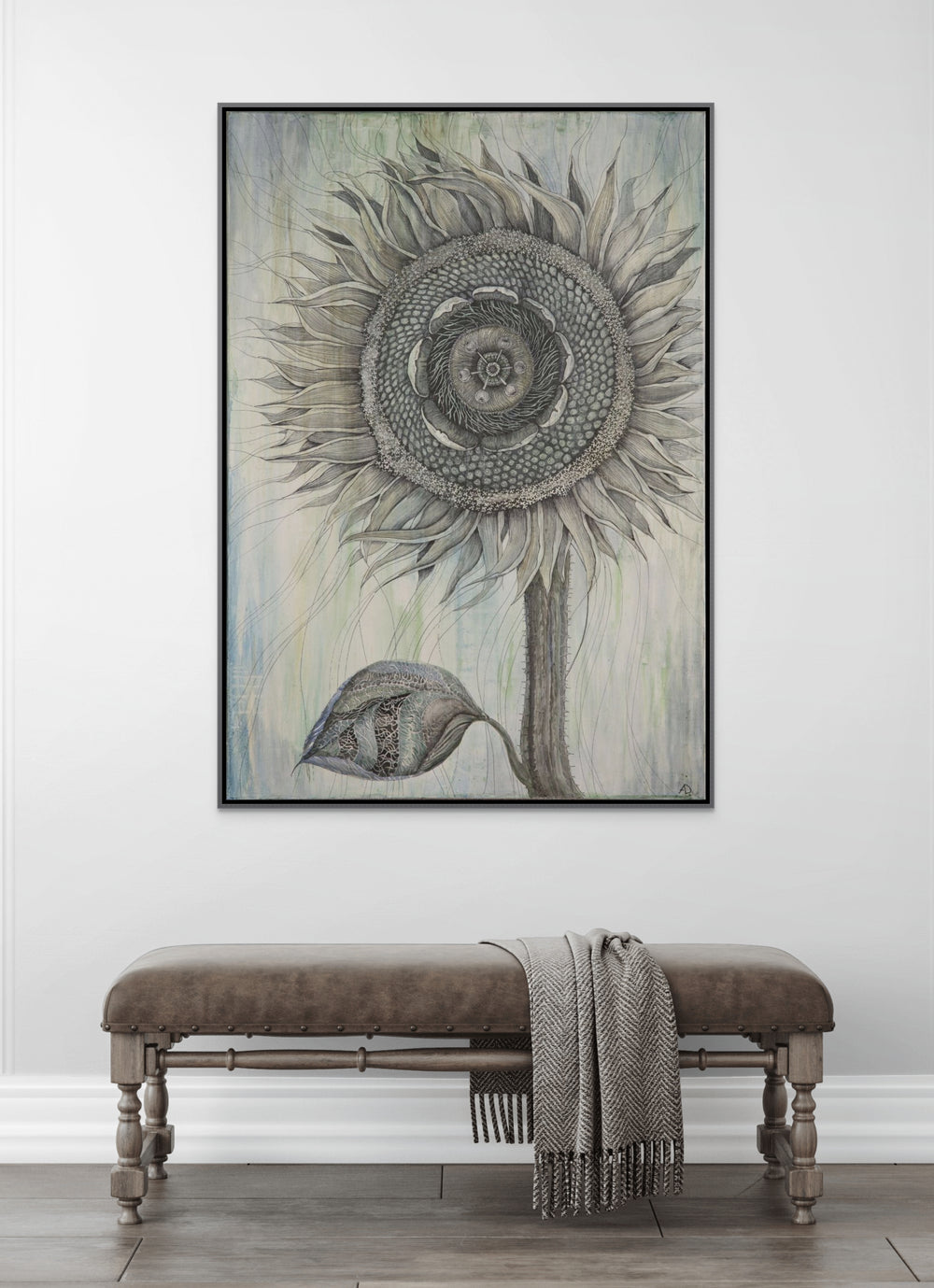 Framed artwork of a sunflower on a white wall above a wooden bench.