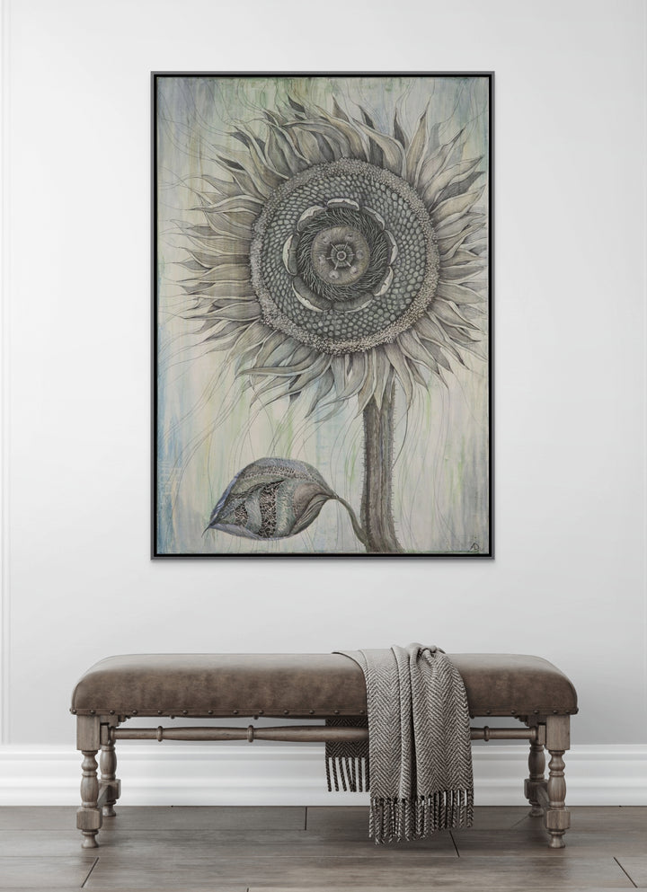 Framed artwork of a sunflower on a white wall above a wooden bench.