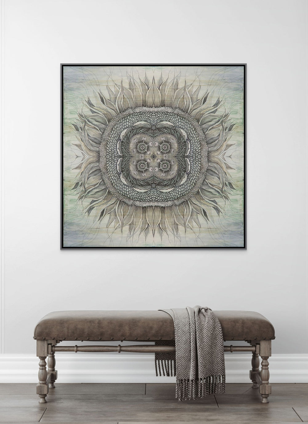 Decorative mandala art piece on a wall above a bench with a blanket.