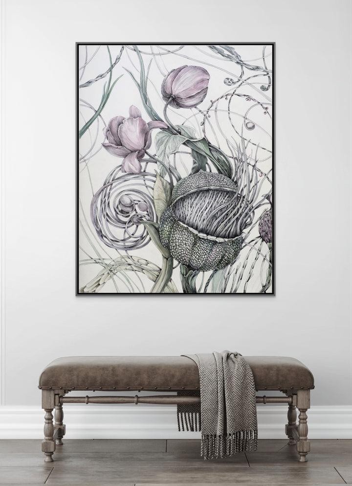 Framed botanical artwork on a wall above a bench with a blanket.
