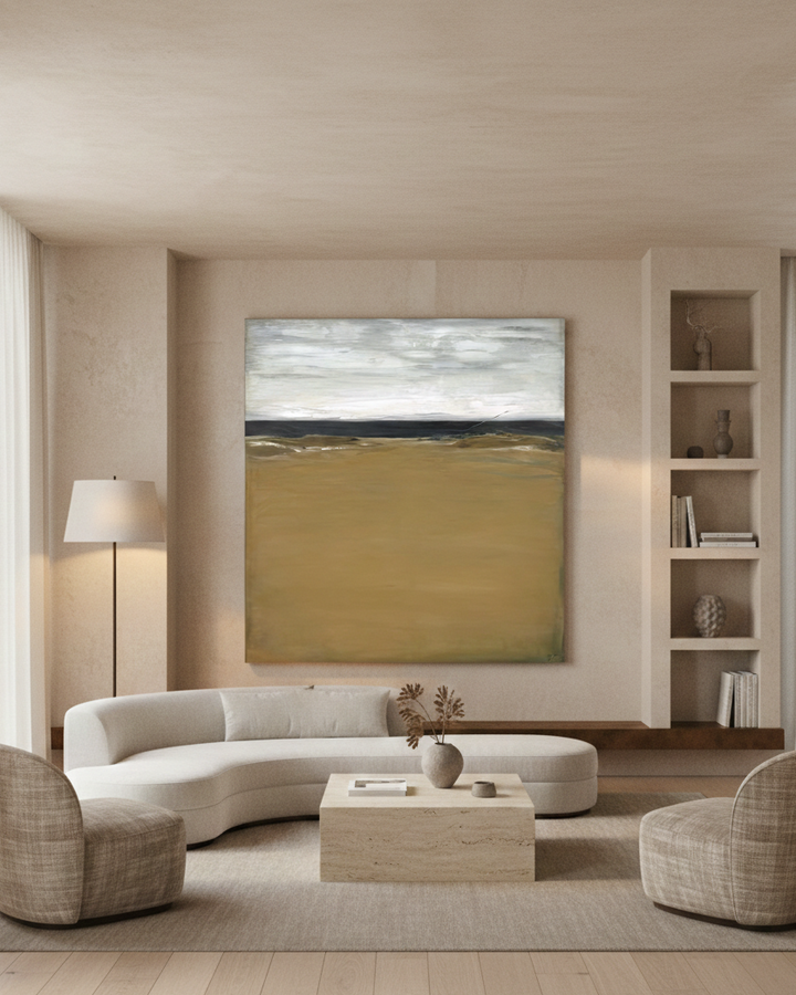 Modern living room with a curved sofa, abstract painting, and bookshelf.