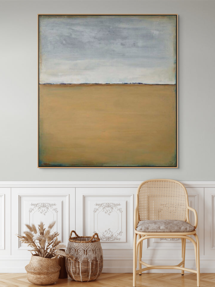 Square framed canvas print with muted blue and beige abstract landscape.
