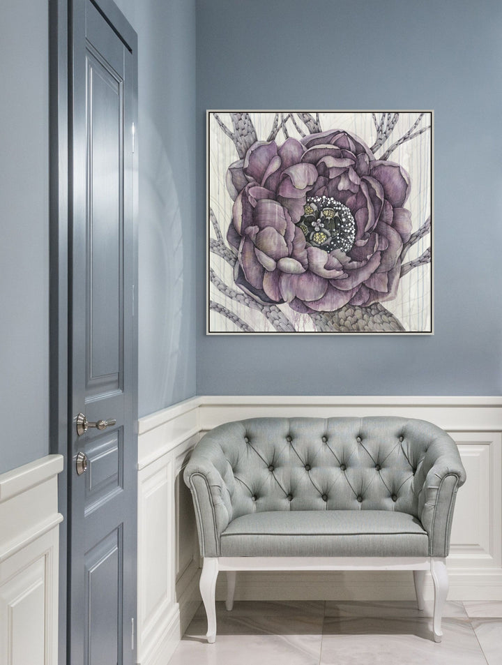 Framed artwork of a purple peony flower on a wall above a gray tufted sofa.